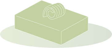 Ein rechteckiger Block Butter mit einer eingerollten Scheibe darauf, auf einem ovalen Untergrund.