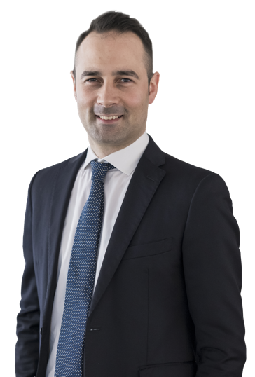 Eine lächelnde Person in einem Anzug und Hemd vor weißem Hintergrund.