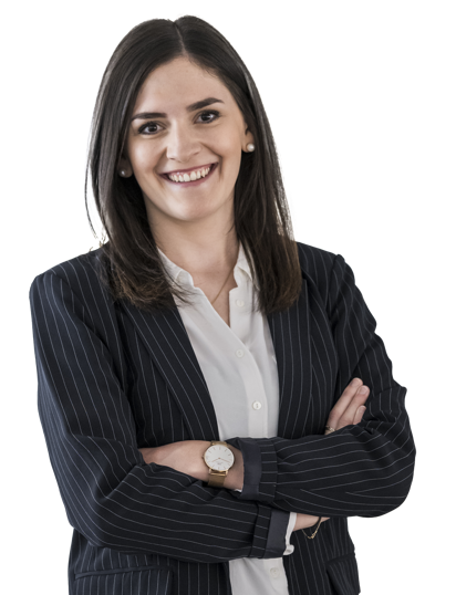 Frau mit Blazer, die die Arme verschränkt hält, vor weißem Hintergrund.